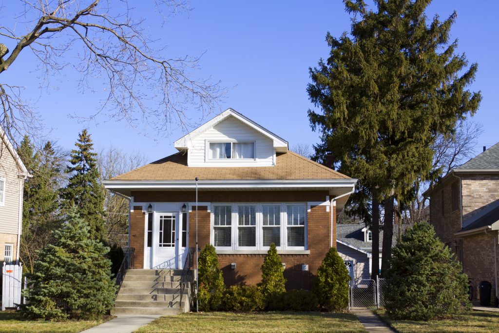 A brick home with gutters in the front