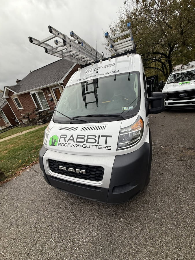 Roofing and gutter company trucking home driveway